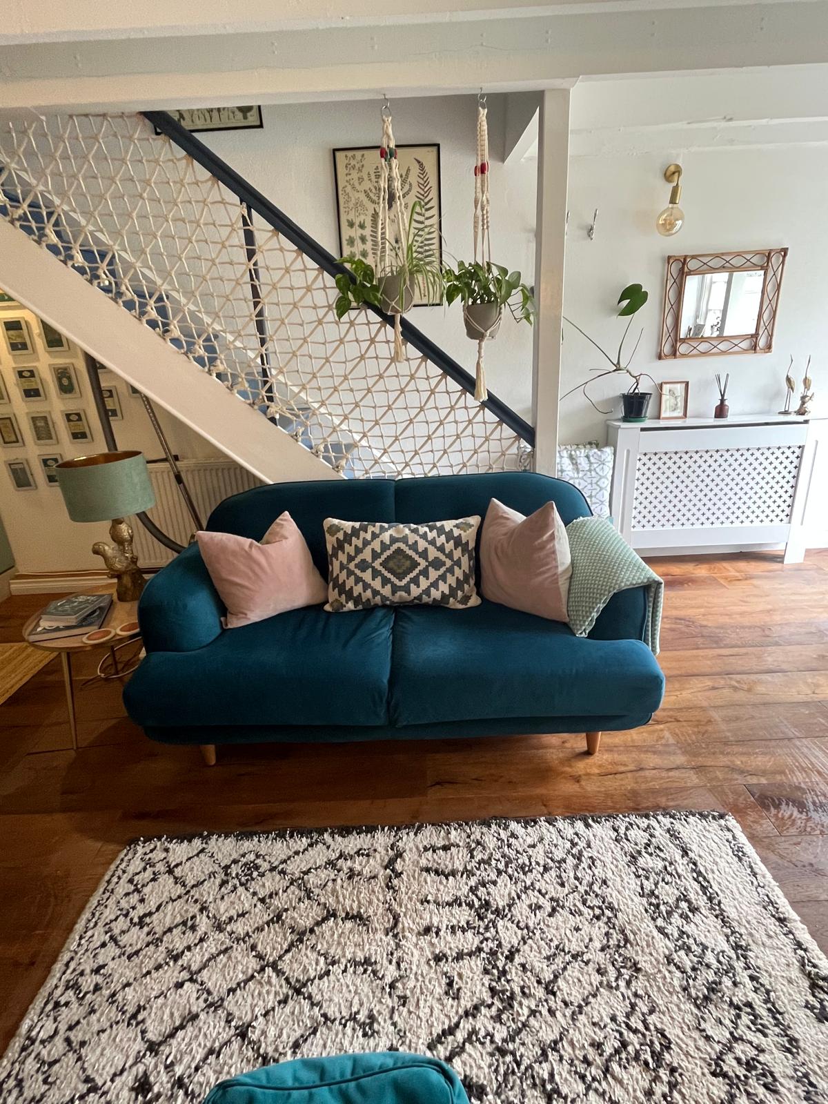 Sitting room with velvet sofa and staircase